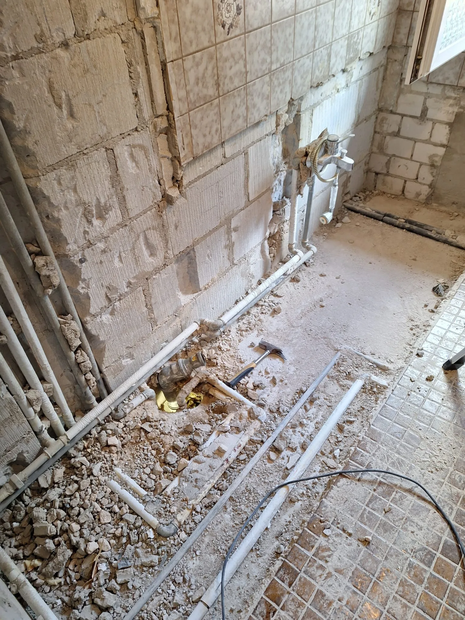 Sanierung eines Badezimmers mit rohen Wänden und sichtbaren Rohren