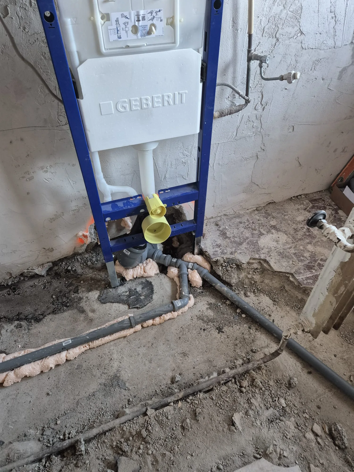 Installation einer Geberit Spülung in einem Badezimmer mit sichtbaren Wasserrohren