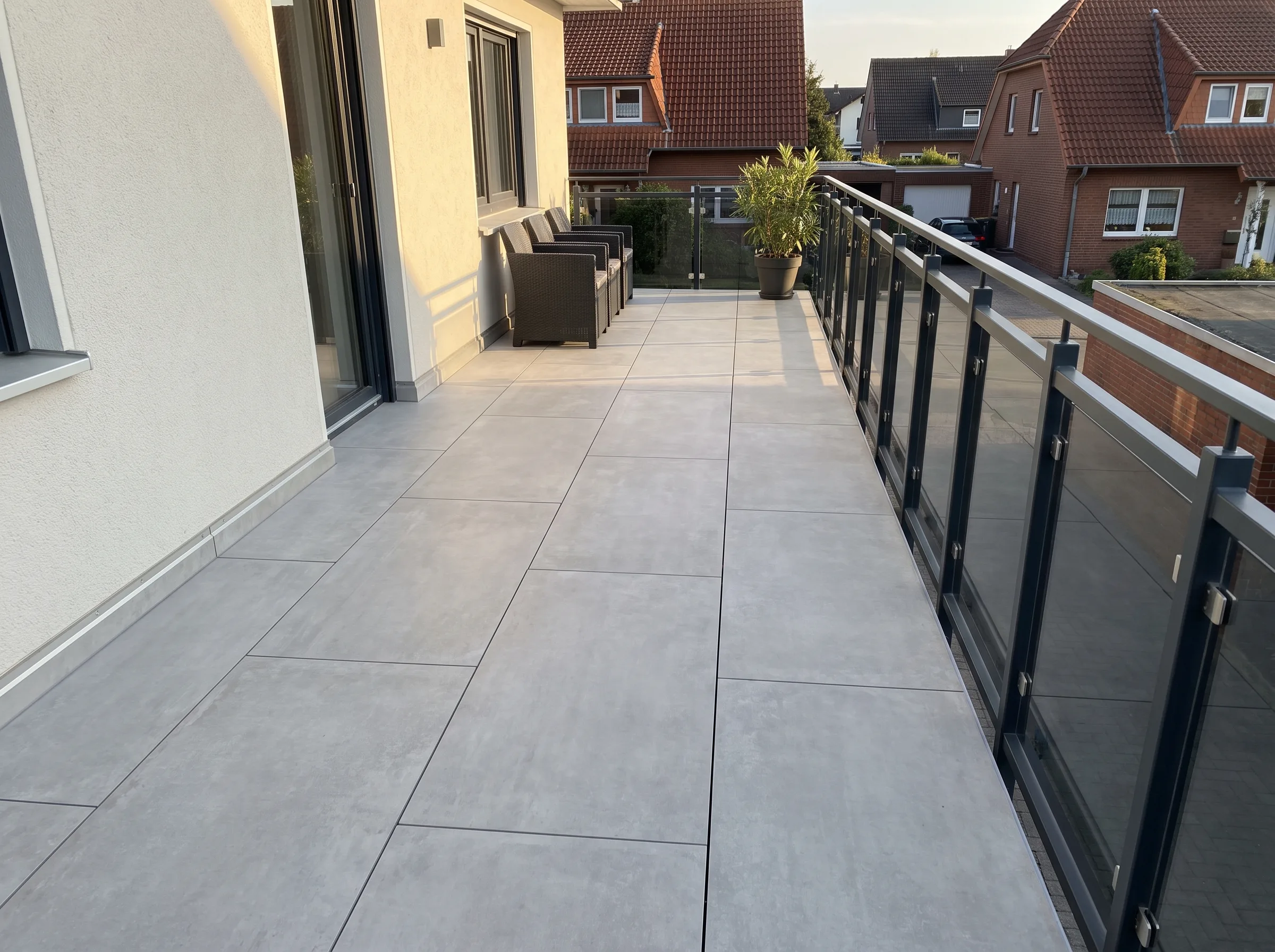 Moderne Terrasse mit großen Fliesen und Sichtschutz, ideal für Badsanierung oder Terrassenbau
