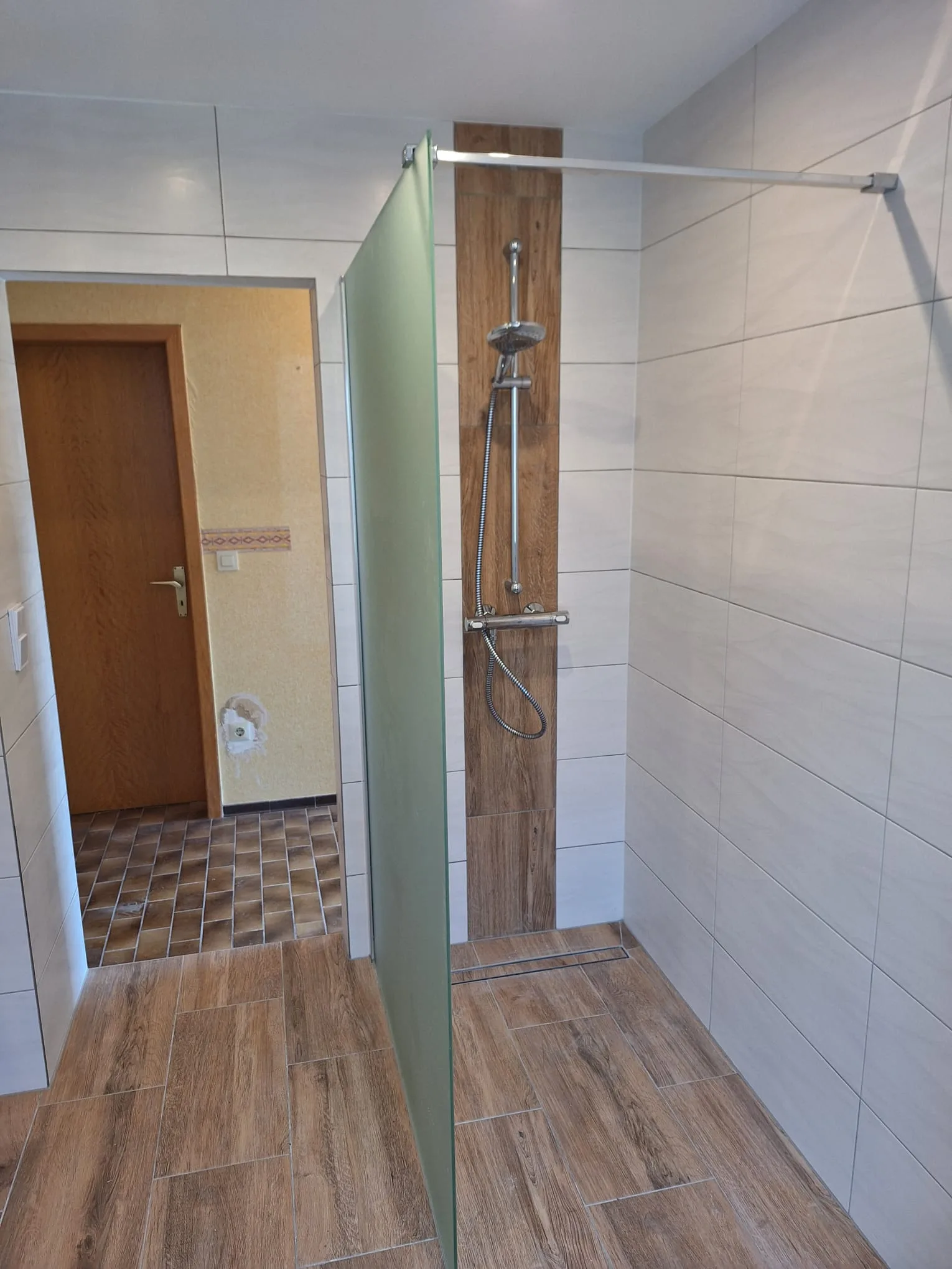 Modernes Badezimmer mit Glasduschwand und Holzverkleidung