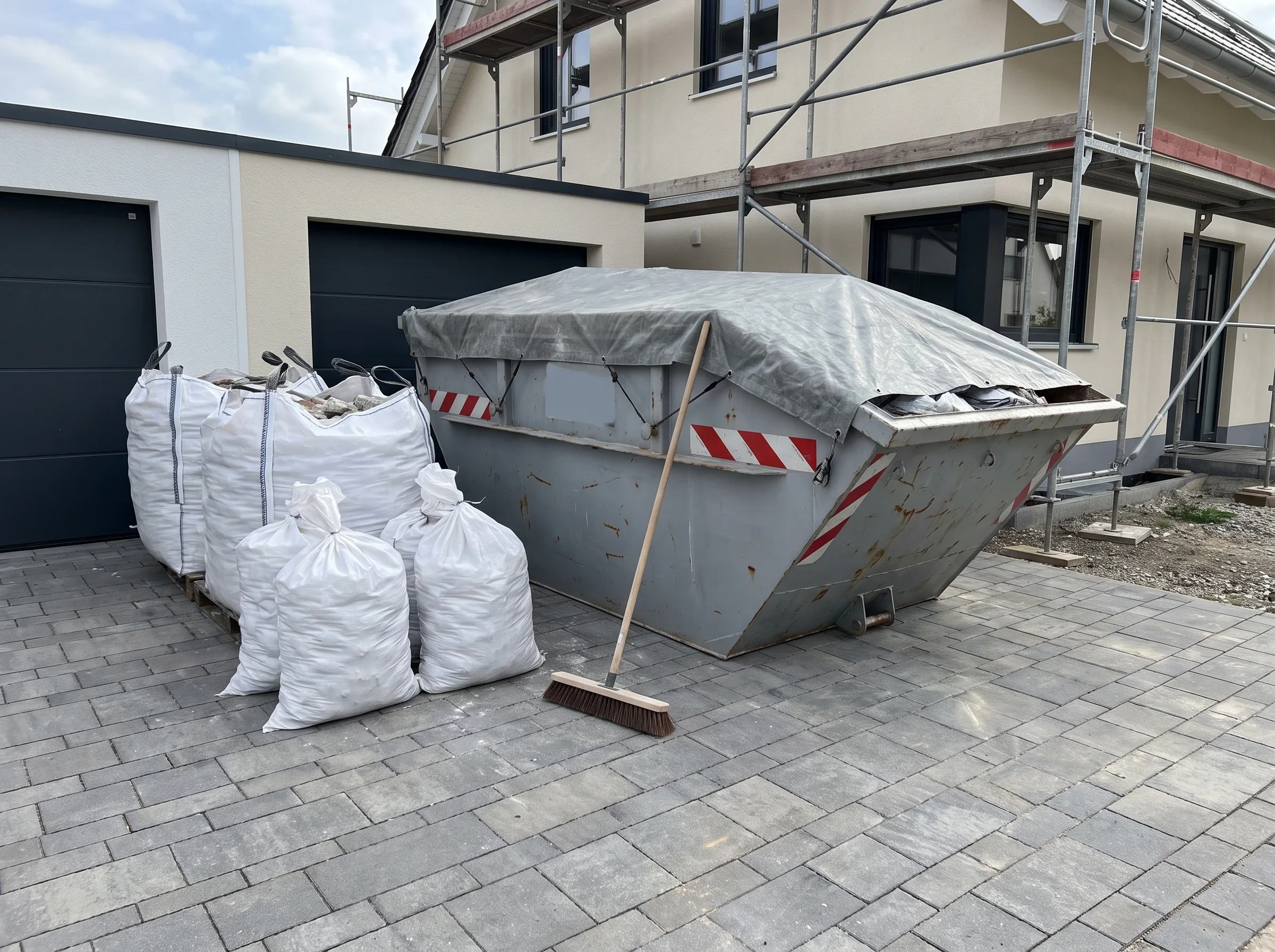 Baustelle mit Abfallcontainer und Baustellenmaterialien