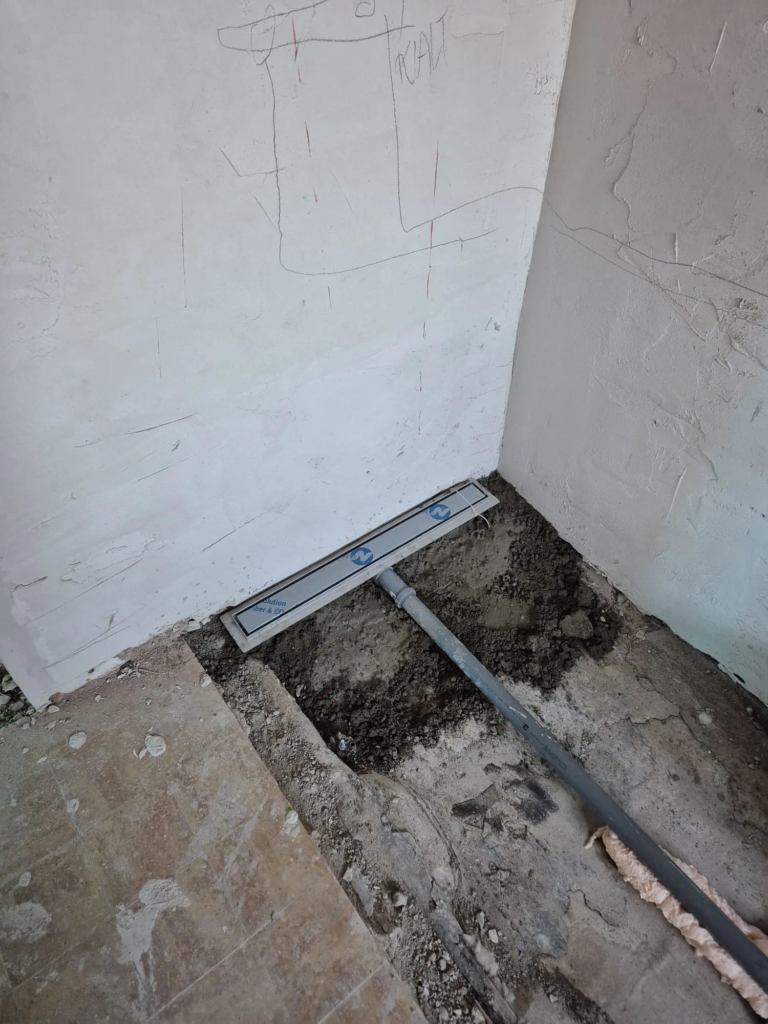 Sicht auf eine Baustelle mit einem installierten Estrich und einem Nivelliergerät