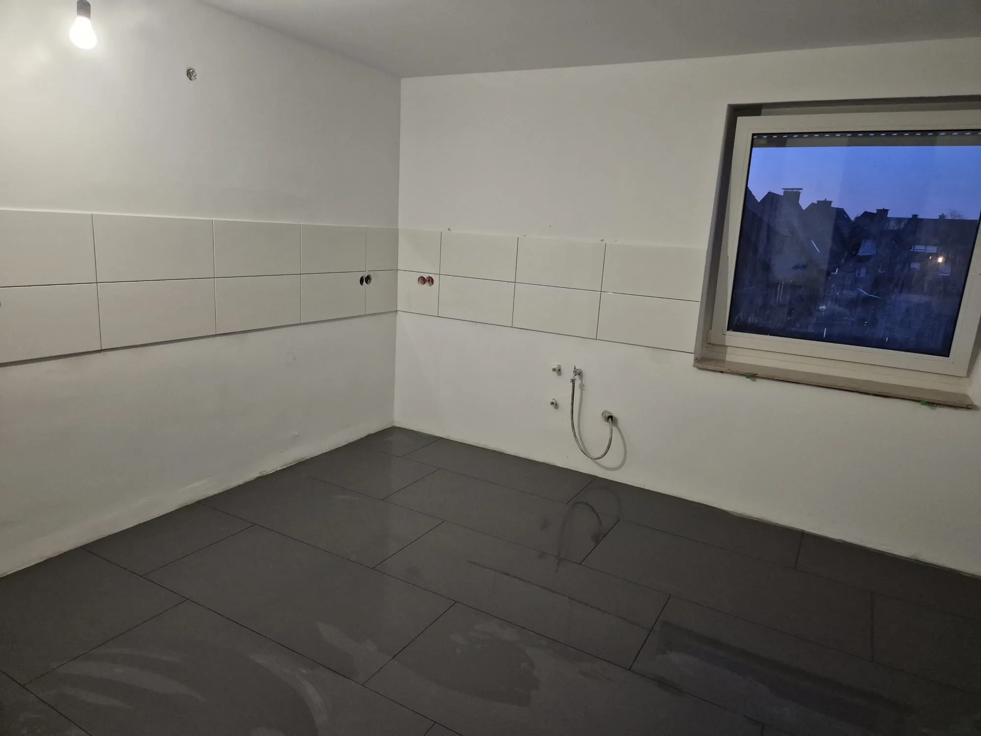 Fliesenverlegungsarbeiten in einem leeren Raum mit geschlossenen Wänden