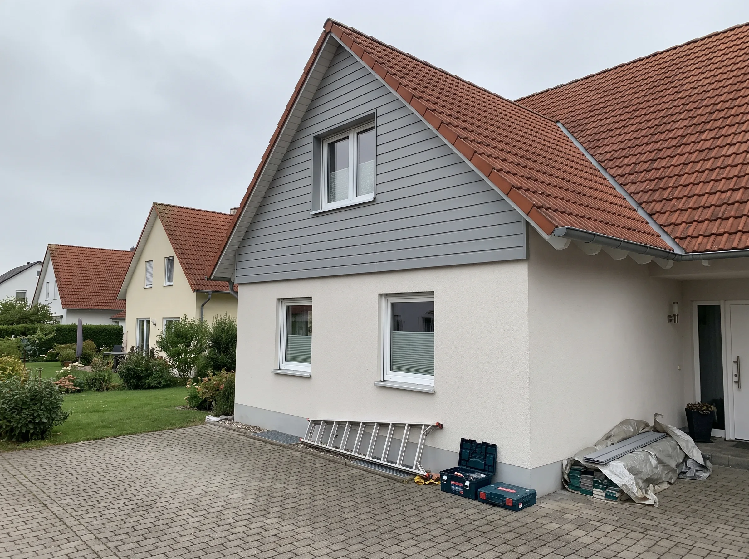 Außenansicht eines Hauses mit neuer Fassadenverkleidung und instand gesetzten Fenstern