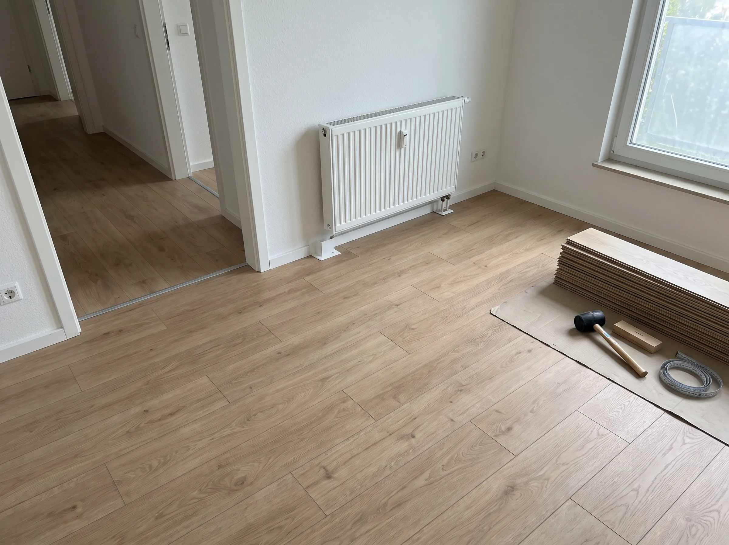 Fußbodenverlegung mit Laminat in einem renovierten Raum