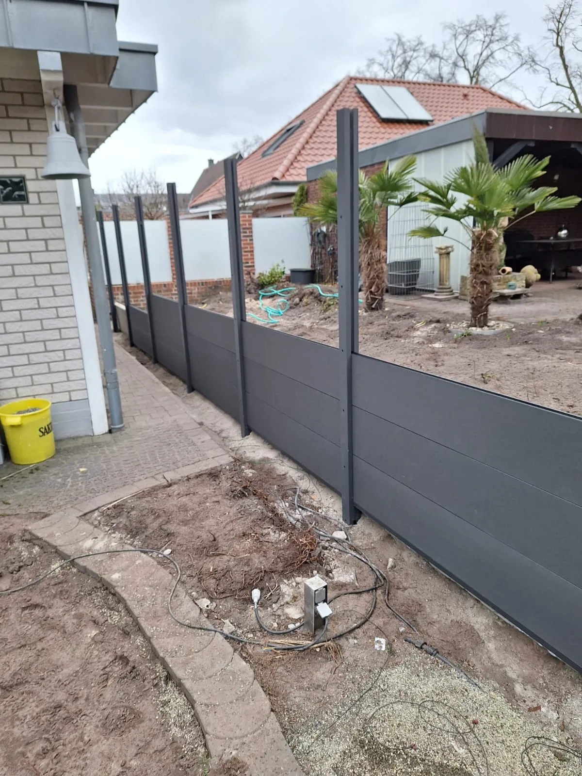 Neue Sichtschutzzauninstallation im Garten mit modernen Paneelen