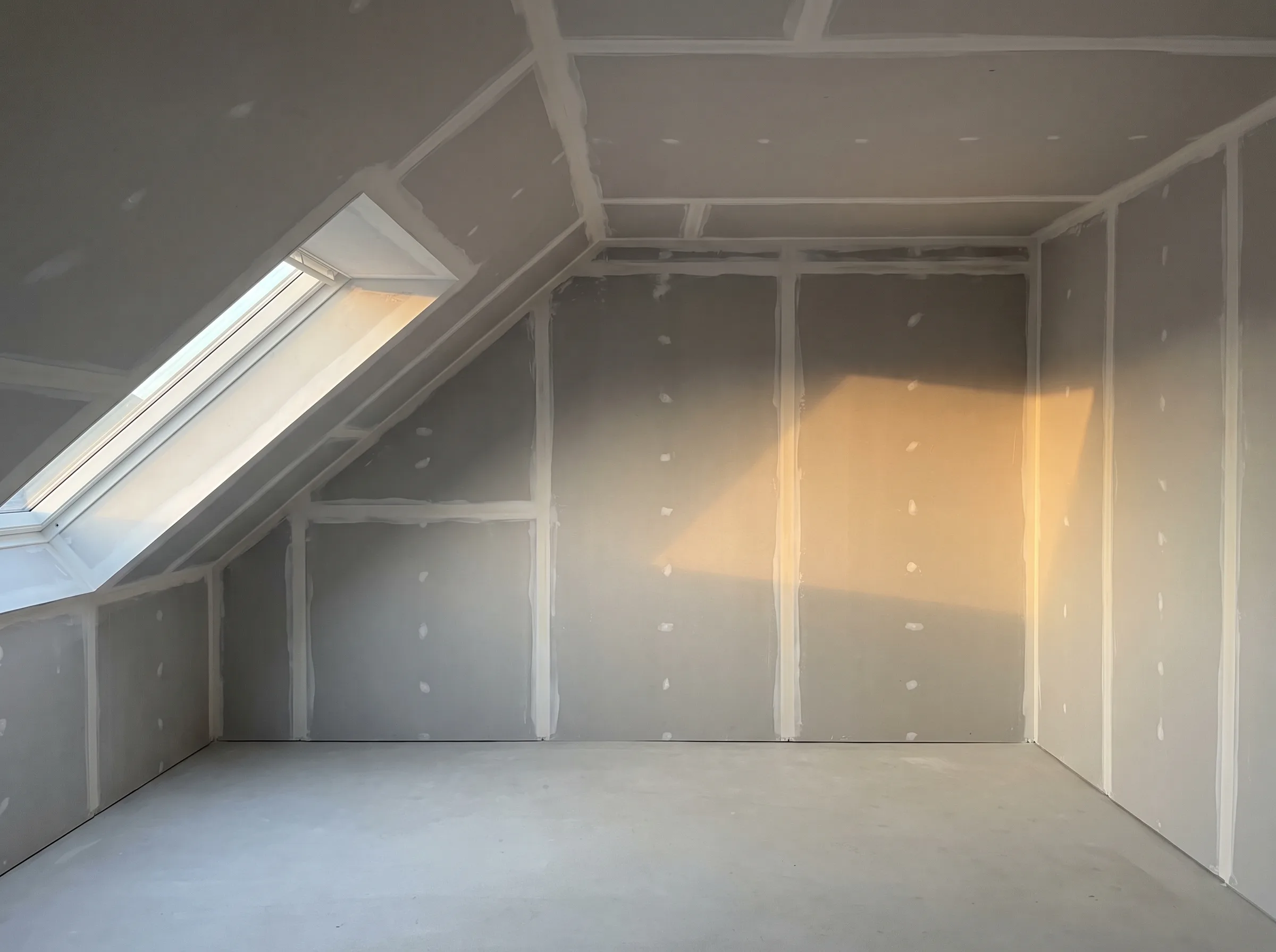 Innenraum mit Trockenbauwänden und Fenster, bereit für die Endbearbeitung