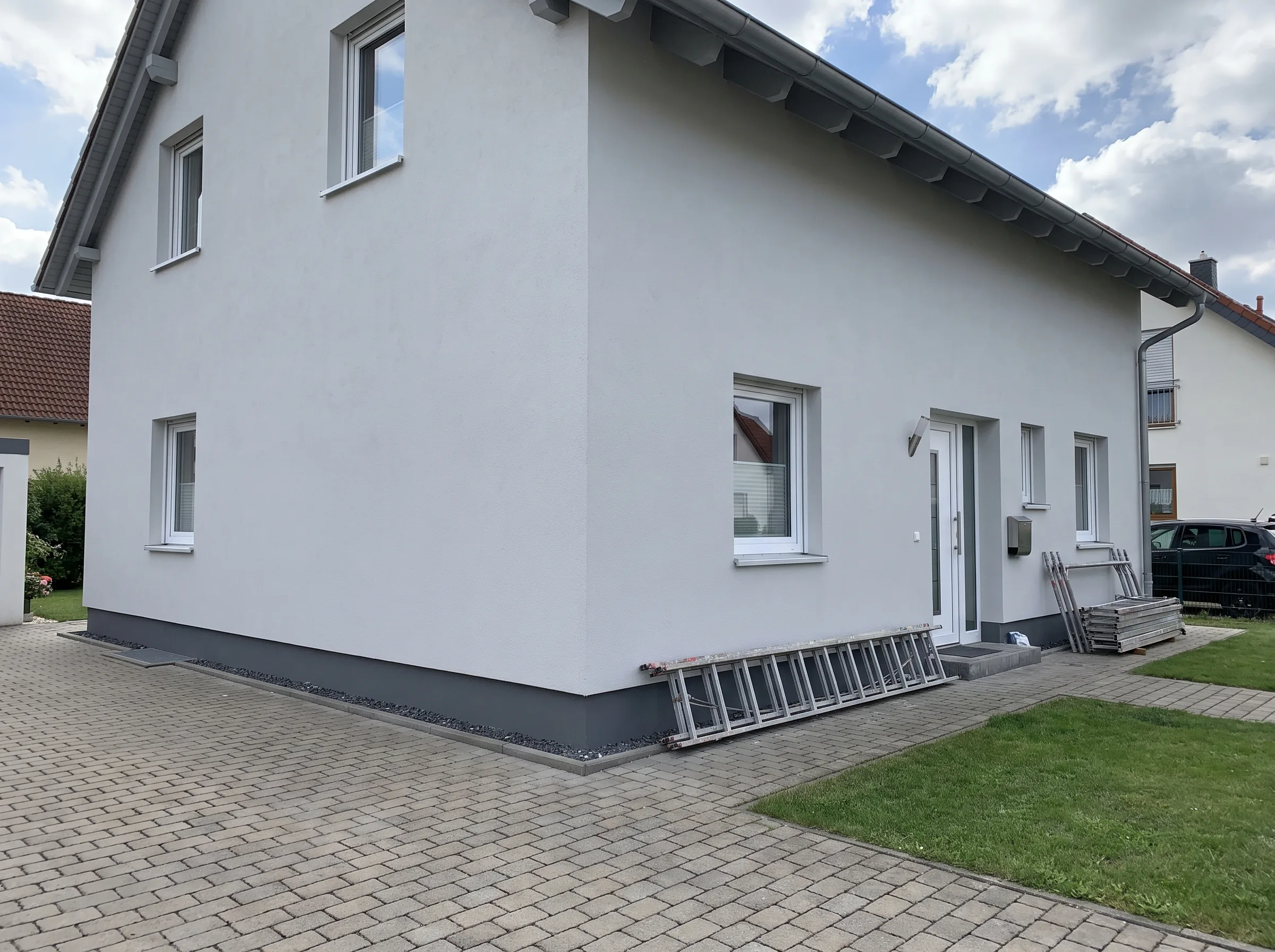 Ansicht eines Hauses mit neuer Fassadenverkleidung und modernem Außenbereich